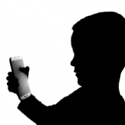 Silhouette of a young boy with a smartphone in his hands