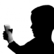 Silhouette of a young boy with a smartphone in his hands