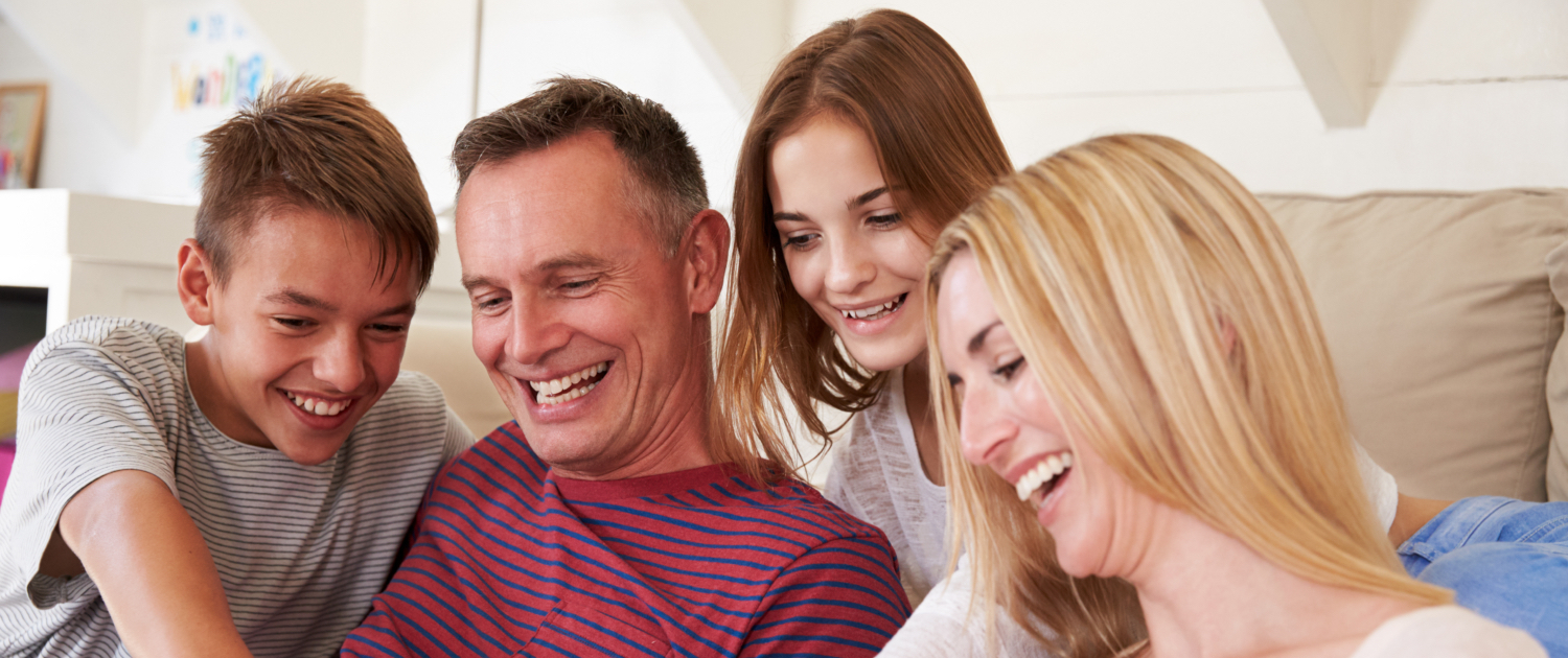 Image of a family (son, father, daughter and mother) all smiling