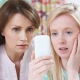 Image of mother and daughter looking worrying at the smartphone the daughter is holding in her right hand